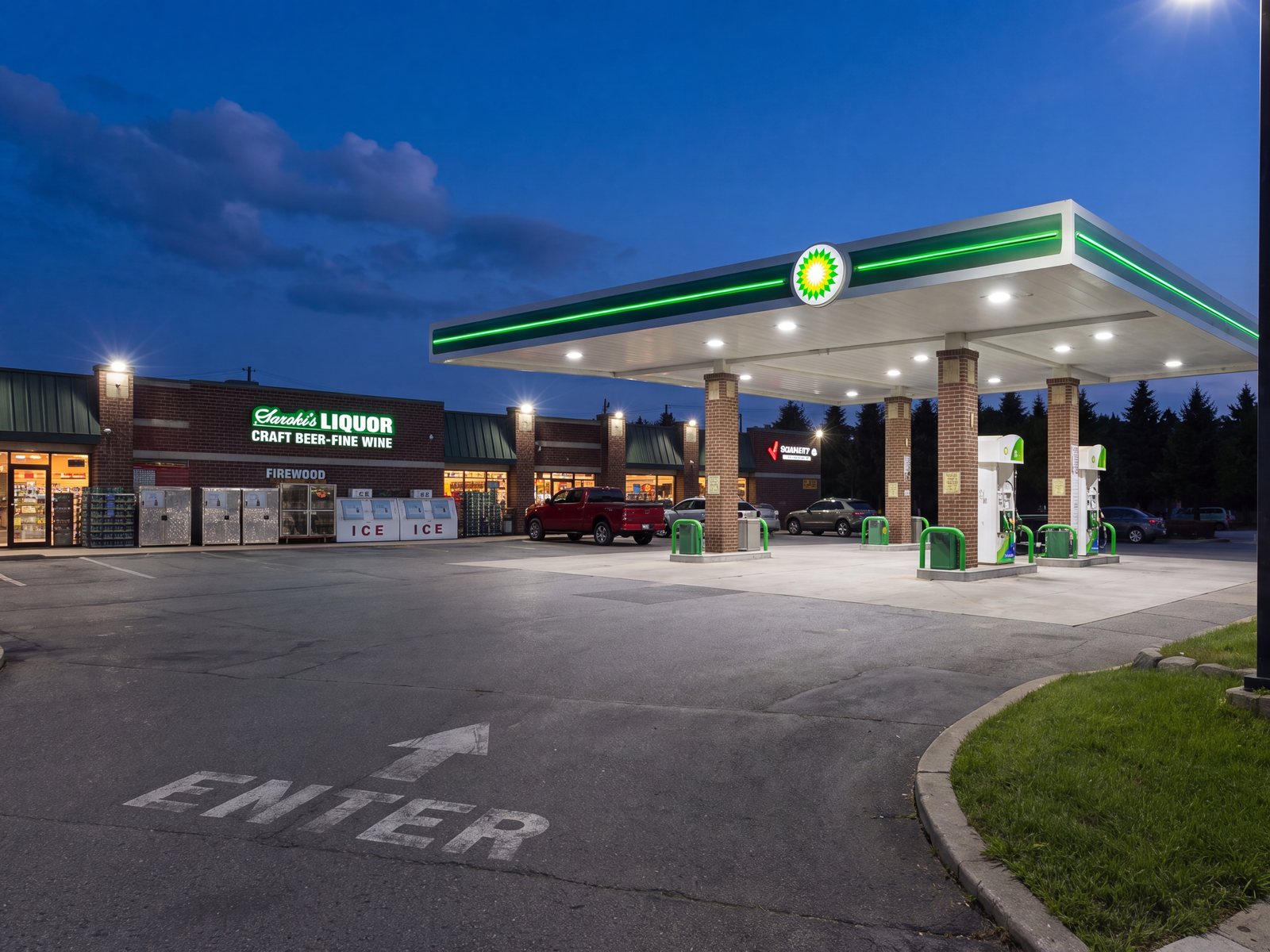 The family's Wixom store at night: Saroki's Liquor beside the lit BP forecourt